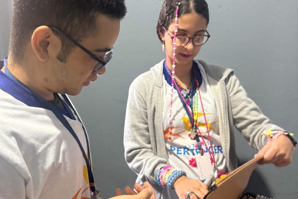 Dois participantes organizando pastas na aula de Auxiliar Administrativo